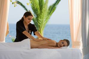 Eine Frau erhält eine Massage im Hotel am Strand mit Meerblick.