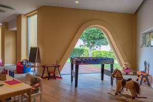 Kinderzimmer im Mediterranean Beach Hotel mit Tisch, Stühlen und Spielzeug.