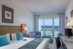 Hotelzimmer mit Meerblick im Mediterranean Beach Hotel mit großem Bett und Wohnzimmerbereich