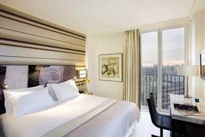 H10 London Waterloo Hotelzimmer mit Bett, Schreibtisch und Blick auf die Stadt.