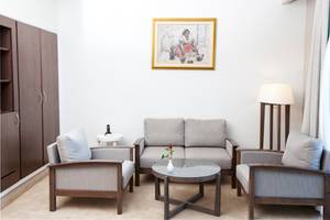 Wohnzimmer im El Mouradi Hammamet Hotel mit Sofa, Tisch, Lampe und Bild an der Wand.