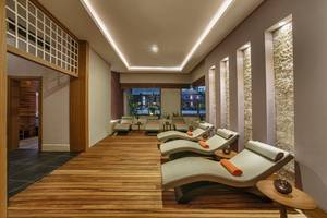 Loungebereich im Aska Lara Resort & Spa mit Holzboden und modernen Liegestühlen.