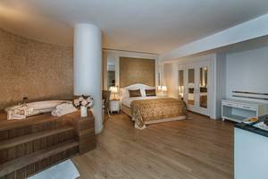 Hotelzimmer im Aska Lara Resort & Spa mit Bett, Badewanne und Essbereich.
