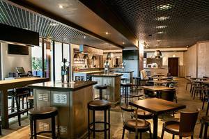 Innenbereich des JA Ocean View Hotels mit Bar, Tischen und Stühlen.