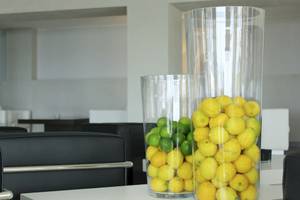 In einem Raum des BG Hotel Nautico Ebeso stehen zwei Glasvasen voller Zitronen und Limetten auf einem Tisch.