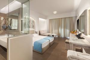 Hotelzimmer im Aeolos Beach Hotel auf Kos mit zwei Betten, Badezimmer und Sitzbereich.