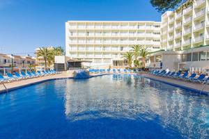 Blick auf den Pool des Hotels Moon Dreams Coral Beach mit Liegen und Palmen im Hintergrund.