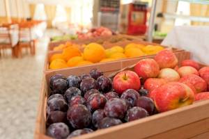 Frische Obstsorten in einem Restaurant im Hotel Moon Dreams Coral Beach. Äpfel und Pflaumen in Holzkisten.
