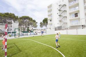 Kinder spielen Fußball auf einem Kunstrasenplatz im Moon Dreams Coral Beach Hotel.