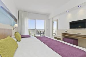 Helle Hotelzimmer im Moon Dreams Coral Beach mit zwei Betten, Balkon und moderner Einrichtung.