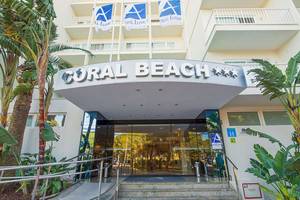 Eingang des Hotels Moon Dreams Coral Beach mit modernen Elementen und tropischer Vegetation.