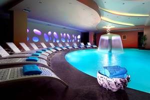 Spa-Bereich des Dimitra Beach Hotel & Suites mit Pool und Liegen.