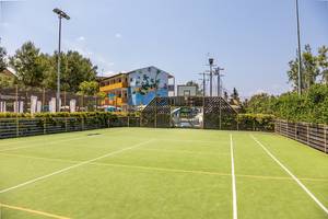 Tennisplatz des Zafiro Tropic Hotels mit einem Gebäude im Hintergrund.