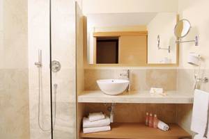 Badezimmer des Zafiro Tropic Hotels mit einer großen Spiegel und einer weißen Badewanne.