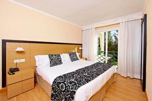 Hotelzimmer mit Doppelbett, Balkon und Ausblick auf Bäume im Zafiro Tropic Hotel.