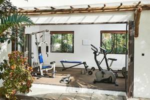 Fitnessraum im Hotel The Ravenala Attitude mit Geräten und Pflanzen davor.