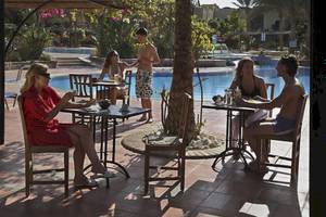 Gäste sitzen auf der Terrasse des Jaz Solaya Hotels an Tischen.