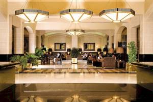 Lobby des Jaz Solaya Hotels mit gemusterten Kronleuchtern und Gästen, die sich entspannen.