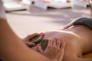 Eine Person, die eine Massage im Ibiza Sun Apartments Hotel genießt, mit Steinen auf dem Rücken.