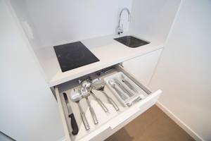 Foto von einer modernen Küche mit einer Kochplatte, einem offenen Schrank mit Kochgeschirr und einer Spüle in Ibiza Sun Apartments.