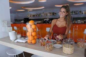 Frau in der Hotelbar bereitet Orangen für die Gäste vor