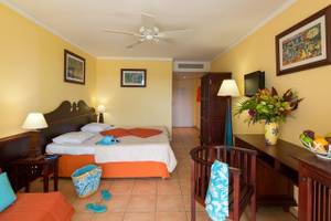 Hotelzimmer im Pierre & Vacances Village Sainte Luce mit Bett, Schreibtisch, Stühlen und Dekor.