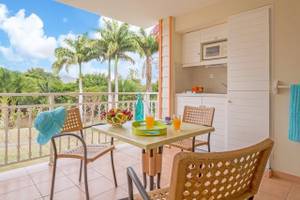 Balkon mit Frühstückstisch und Blick auf Palmen im Pierre & Vacances Village Sainte Luce