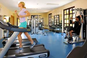 Fitnessstudio im Hotel Iberostar Playa Alameda mit Frau auf dem Laufband und Mann an der Maschine.