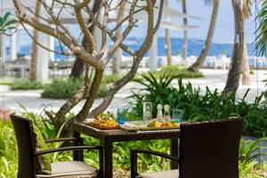Außenbereich des Kurumba Maldives Hotels mit einem Tisch, auf dem Essen serviert wird.