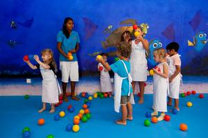 Kinder spielen mit Bällen im Aquarium des Kurumba Maldives.