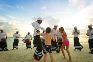 Eine Tanzgruppe am Strand des Kurumba Maldives Hotels mit einem kleinen Jungen und Mädchen.