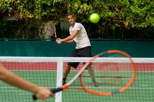Tennisspieler auf einem Tennisplatz im Kurumba Maldives.