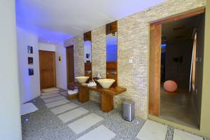 Badezimmer im Le Domaine de L'Orangeraie Resort & Spa mit zwei Waschbecken und einer offenen Tür.