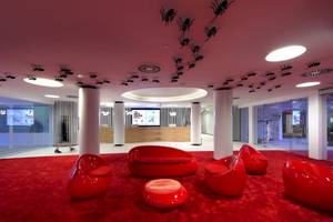Lobby des Ushuaia Ibiza Beach Hotels mit roten Möbeln und pinker Decke.