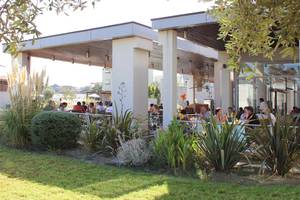 Außenterrasse des Sentido Port Royal Villas & Spa Hotels mit Gästen, die sitzen und essen.