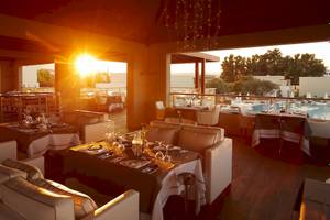Sonnenuntergang im Port Royal Restaurant mit Blick auf den Pool und beleuchteten Tischen.