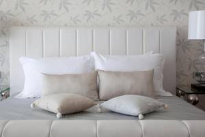 Bett im Sentido Port Royal Villas & Spa mit weißen Kissen und Dekokissen