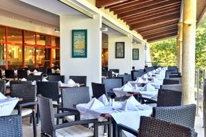 Restaurantterrasse im Kaliakra Beach Hotel mit gedeckten Tischen und Stühlen.