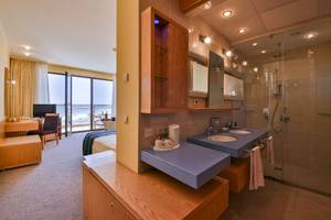Badezimmer im Kaliakra Beach Hotel mit Blick auf das Meer, zwei Waschbecken und einer Dusche.