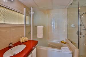 Badezimmer im Kaliakra Beach Hotel mit Badewanne, Dusche und Waschbecken.