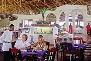 Innenansicht des Restaurants im VOI Kiwengwa Resort mit Gästen und Kellnern.