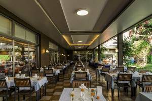 Innenansicht des Restaurants im Calimera Hane Garden Hotel mit gemustertem Boden und gedeckten Tischen.