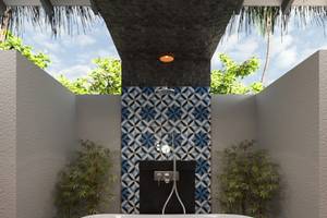 Dusche im You & Me Maldives Hotel mit blauem Muster an der Wand und Pflanzen.