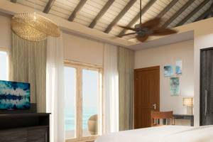 Schlafzimmer mit Meerblick im You & Me Maldives Hotel mit Fernseher, Bett und Schreibtisch.