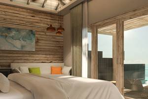 Schlafzimmer mit Meerblick im You & Me Maldives Hotel mit Holzwänden, Bett und Fenstern.