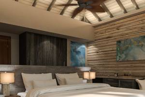 Innenansicht eines Schlafzimmers im You & Me Maldives Hotel mit Holzwänden und einer großen Bett.