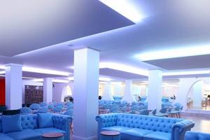 Innenbereich des Sandos El Greco Beach Hotels mit blauen Sofas und Tischen
