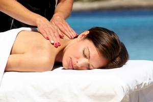 Frau genießt eine Massage am Strand im Sandos El Greco Beach Hotel