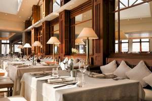 Innenbereich des Porto Sani Hotels mit gedeckten Esstischen und Lampen.