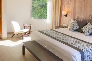 Schlafzimmer im Sandos Caracol Eco Resort mit Bett, Stuhl und Fenster